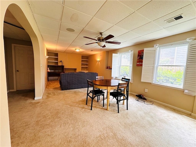 1739 Praters Pt, Dacula, GA 30019 - dining area with arched walkways, baseboards, light carpet, a paneled ceiling, and ceiling fan