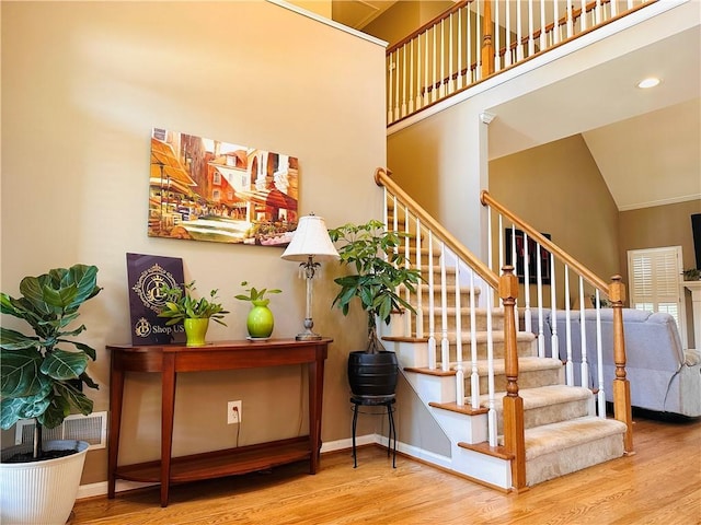 1739 Praters Pt, Dacula, GA 30019 - staircase with wood finished floors, high vaulted ceiling, and baseboards