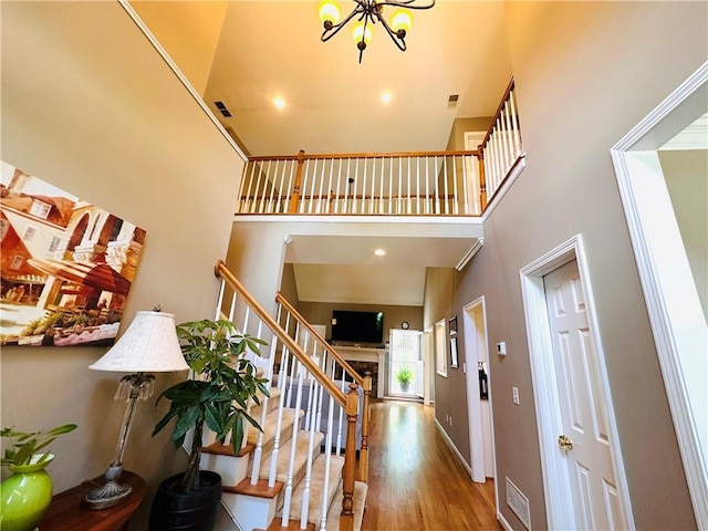1739 Praters Pt, Dacula, GA 30019 - staircase with a towering ceiling, a chandelier, wood finished floors, and baseboards
