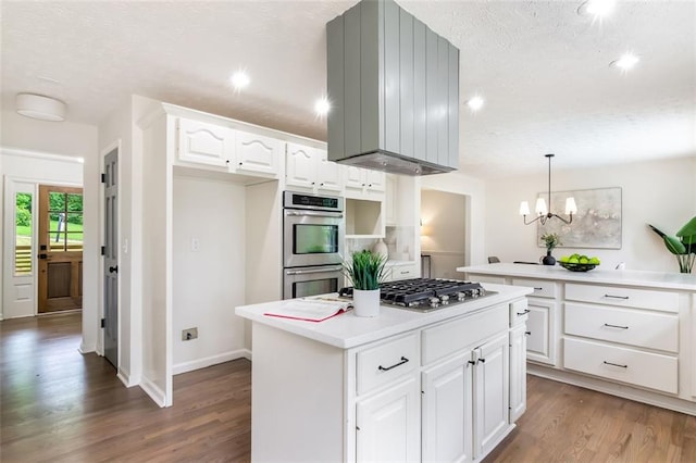 2015 Clipper Straits, Snellville, GA 30078 - kitchen featuring stainless steel appliances, wood finished floors, a textured ceiling, a kitchen island, and a chandelier