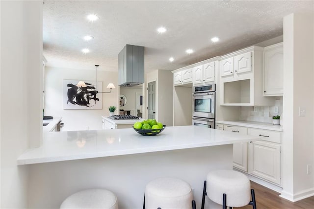 2015 Clipper Straits, Snellville, GA 30078 - kitchen with stainless steel appliances, a peninsula, a breakfast bar area, white cabinetry, and recessed lighting