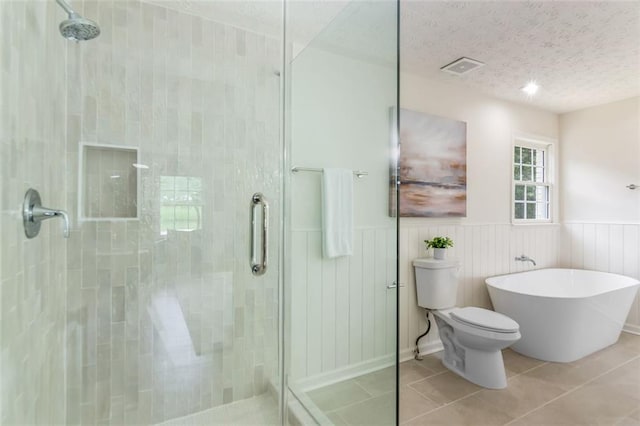 2015 Clipper Straits, Snellville, GA 30078 - full bathroom with a stall shower, a textured ceiling, tile patterned floors, a wainscoted wall, and a freestanding tub