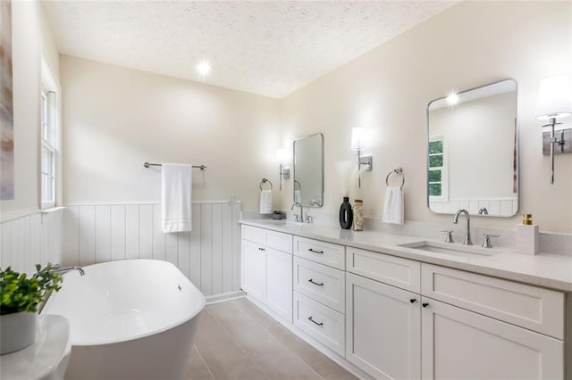 2015 Clipper Straits, Snellville, GA 30078 - full bath featuring a freestanding bath, double vanity, wainscoting, a textured ceiling, and tile patterned flooring