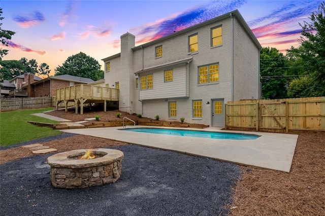 2015 Clipper Straits, Snellville, GA 30078 - back of property with a wooden deck, a chimney, a fenced backyard, a patio, and an outdoor fire pit