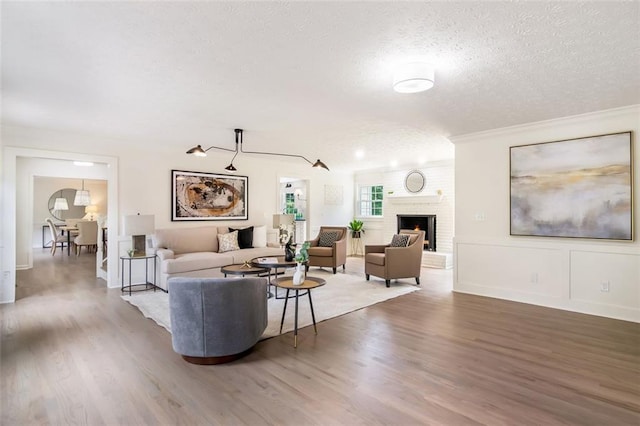 2015 Clipper Straits, Snellville, GA 30078 - living area featuring a textured ceiling, wood finished floors, crown molding, and a fireplace