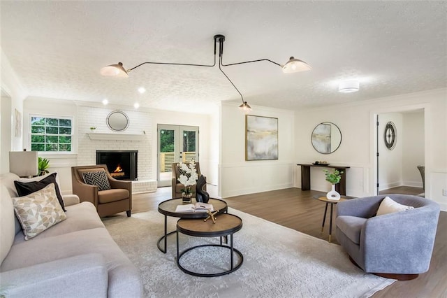 2015 Clipper Straits, Snellville, GA 30078 - living area with a textured ceiling, wood finished floors, a brick fireplace, french doors, and ornamental molding