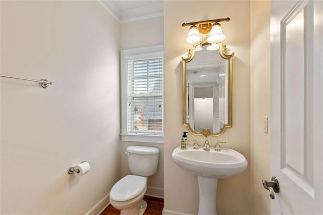 half bath with baseboards, toilet, and ornamental molding