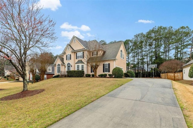 view of front of house with a front lawn and fence