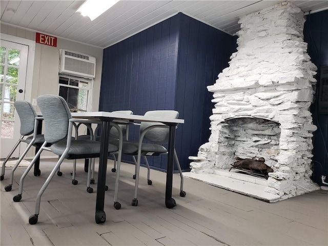 dining area with wood walls, ornamental molding, hardwood / wood-style flooring, and a wall mounted air conditioner