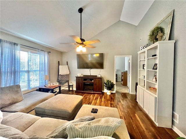 living area featuring lofted ceiling, baseboards, a ceiling fan, and wood finished floors