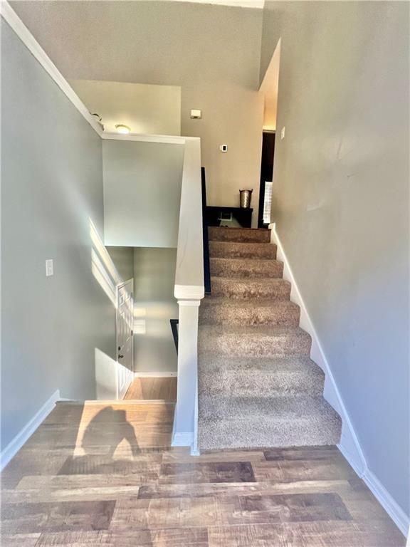 staircase with baseboards and wood finished floors