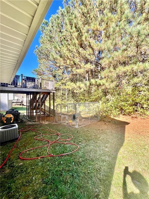 view of yard with cooling unit, fence, a deck, and stairs