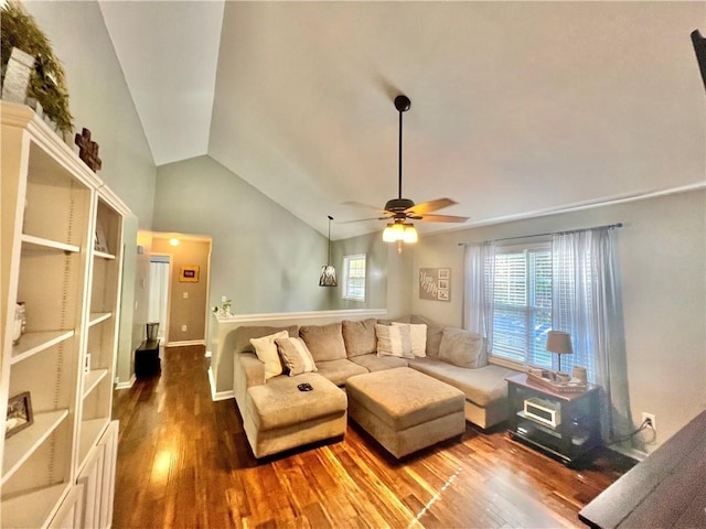 living room with ceiling fan, vaulted ceiling, baseboards, and wood finished floors