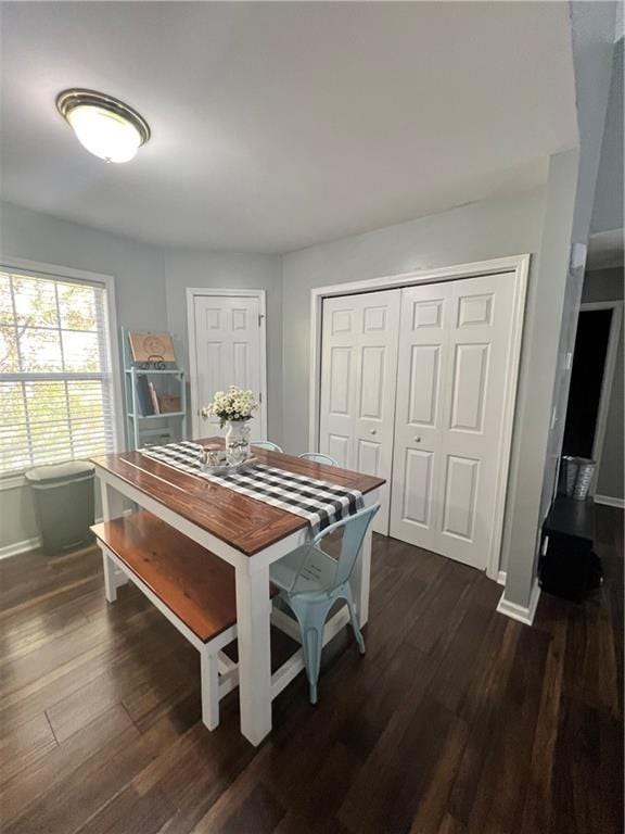 dining area featuring baseboards and dark wood finished floors