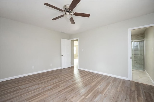 unfurnished bedroom with baseboards, light wood-style floors, ceiling fan, and ensuite bathroom