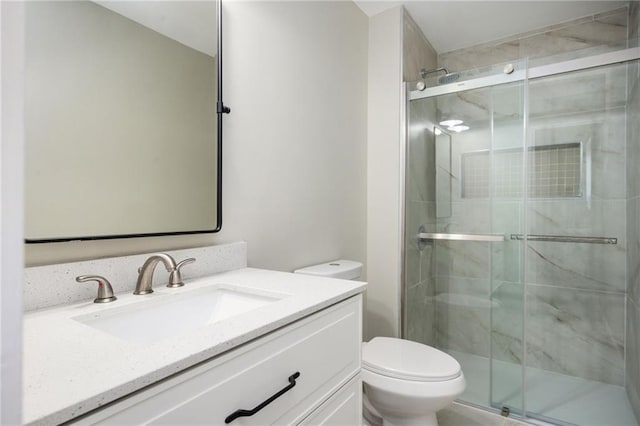 full bathroom featuring a stall shower, toilet, and vanity