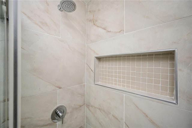 interior details featuring tiled shower