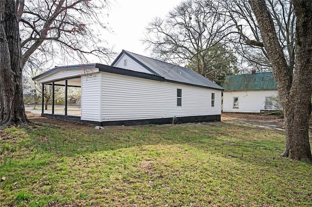 view of side of home featuring a carport and a yard