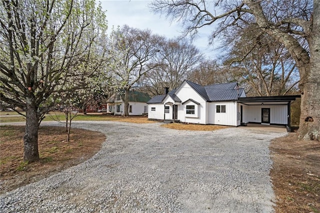 modern inspired farmhouse featuring curved driveway, metal roof, and an attached carport