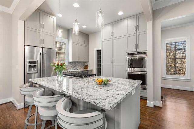 540 Woodall Ave NE, Atlanta, GA 30306 - kitchen featuring a center island, stainless steel appliances, dark wood finished floors, baseboards, and ornamental molding