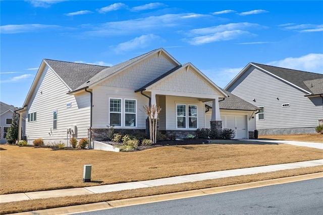 craftsman inspired home with a garage, stone siding, driveway, and a front lawn