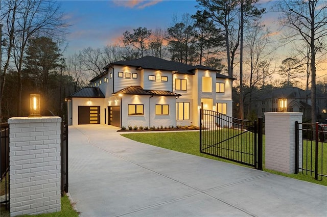 view of front facade with a garage, concrete driveway, a fenced front yard, metal roof, and a standing seam roof