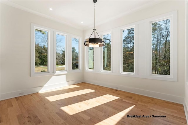 unfurnished dining area with a healthy amount of sunlight, baseboards, and wood finished floors