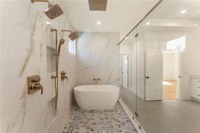 bathroom featuring tile walls, a marble finish shower, recessed lighting, visible vents, and a freestanding bath