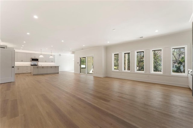 unfurnished living room with baseboards, light wood-style flooring, and recessed lighting