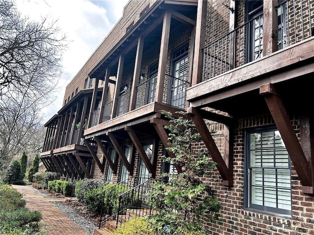 view of side of home with stairway and brick siding