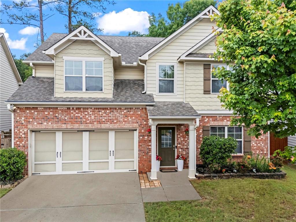 47 Gloster Mill Way, Lawrenceville, GA 30044 - view of front facade with concrete driveway, a shingled roof, a garage, and brick siding