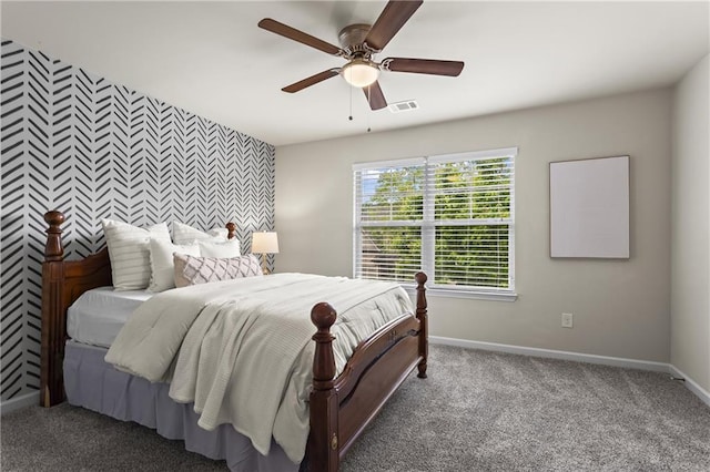 bedroom featuring an accent wall, baseboards, and carpet floors