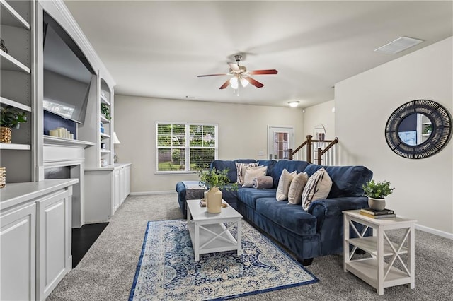 living room featuring ceiling fan, carpet flooring, baseboards, and a fireplace