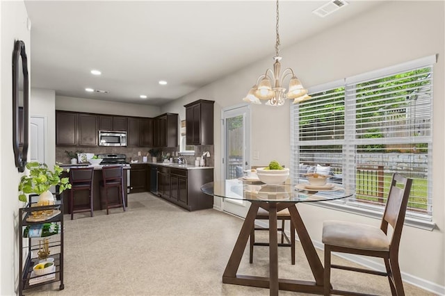 dining room featuring a chandelier, healthy amount of natural light, and recessed lighting