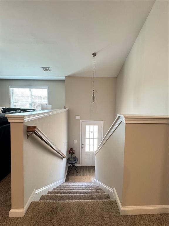 stairway with carpet flooring, visible vents, and baseboards