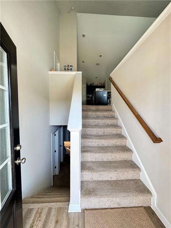 stairs featuring wood finished floors and baseboards