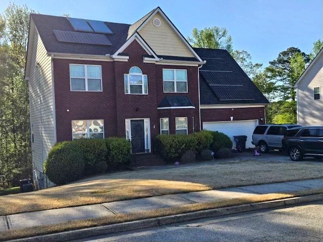 view of front of property featuring solar panels, concrete driveway, a garage, and brick siding