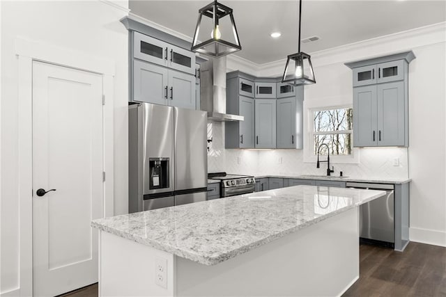 kitchen featuring a kitchen island, glass insert cabinets, stainless steel appliances, and a sink