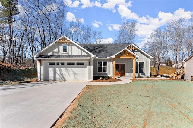 view of front of property with a shingled roof, concrete driveway, board and batten siding, a garage, and a front lawn