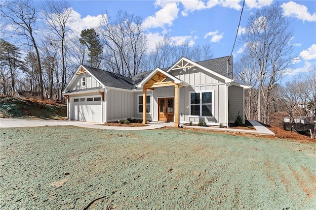 view of front facade featuring driveway, roof with shingles, an attached garage, board and batten siding, and a front yard