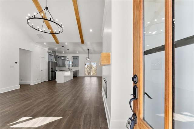 unfurnished living room featuring vaulted ceiling with beams, dark wood-type flooring, recessed lighting, and baseboards