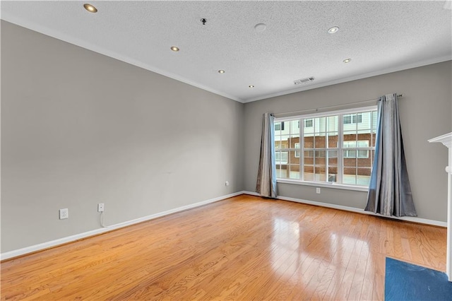 unfurnished room with light hardwood / wood-style floors, crown molding, and a textured ceiling