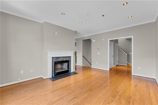 unfurnished living room with crown molding and light hardwood / wood-style flooring