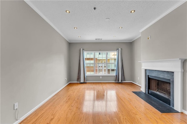 unfurnished living room with a textured ceiling, light wood-type flooring, and ornamental molding