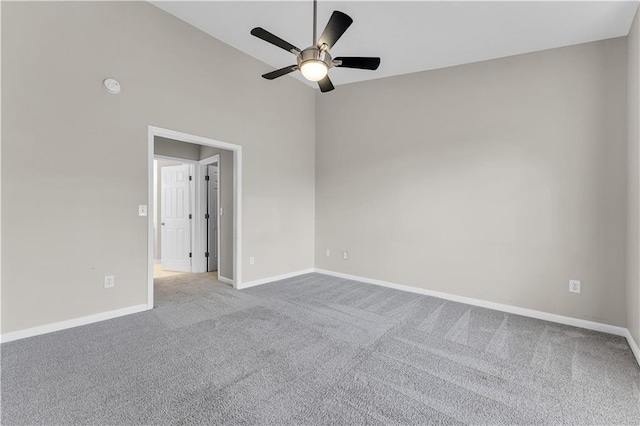 carpeted spare room with ceiling fan and lofted ceiling