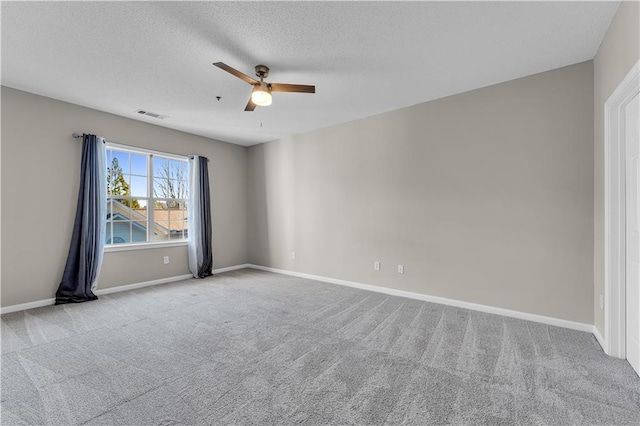 spare room featuring ceiling fan, light carpet, and a textured ceiling