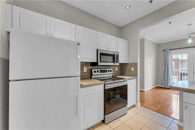 kitchen with white cabinets, backsplash, light tile patterned floors, and stainless steel appliances