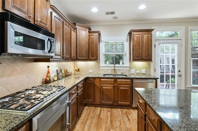 kitchen featuring a healthy amount of sunlight, visible vents, a sink, light wood-style floors, and stainless steel appliances