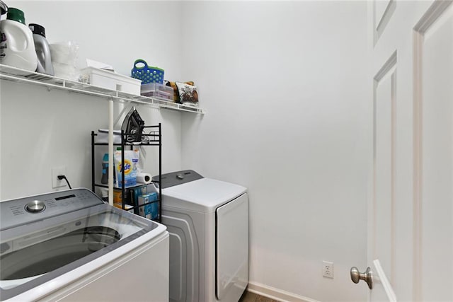 laundry room with laundry area, baseboards, and separate washer and dryer