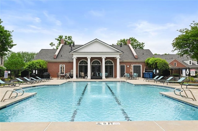 pool with a patio and fence